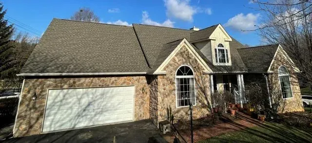 A large house with a garage and a large roof.