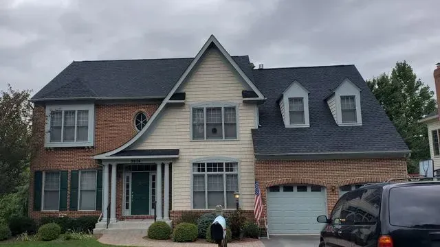 A large brick house with a car parked in front of it.