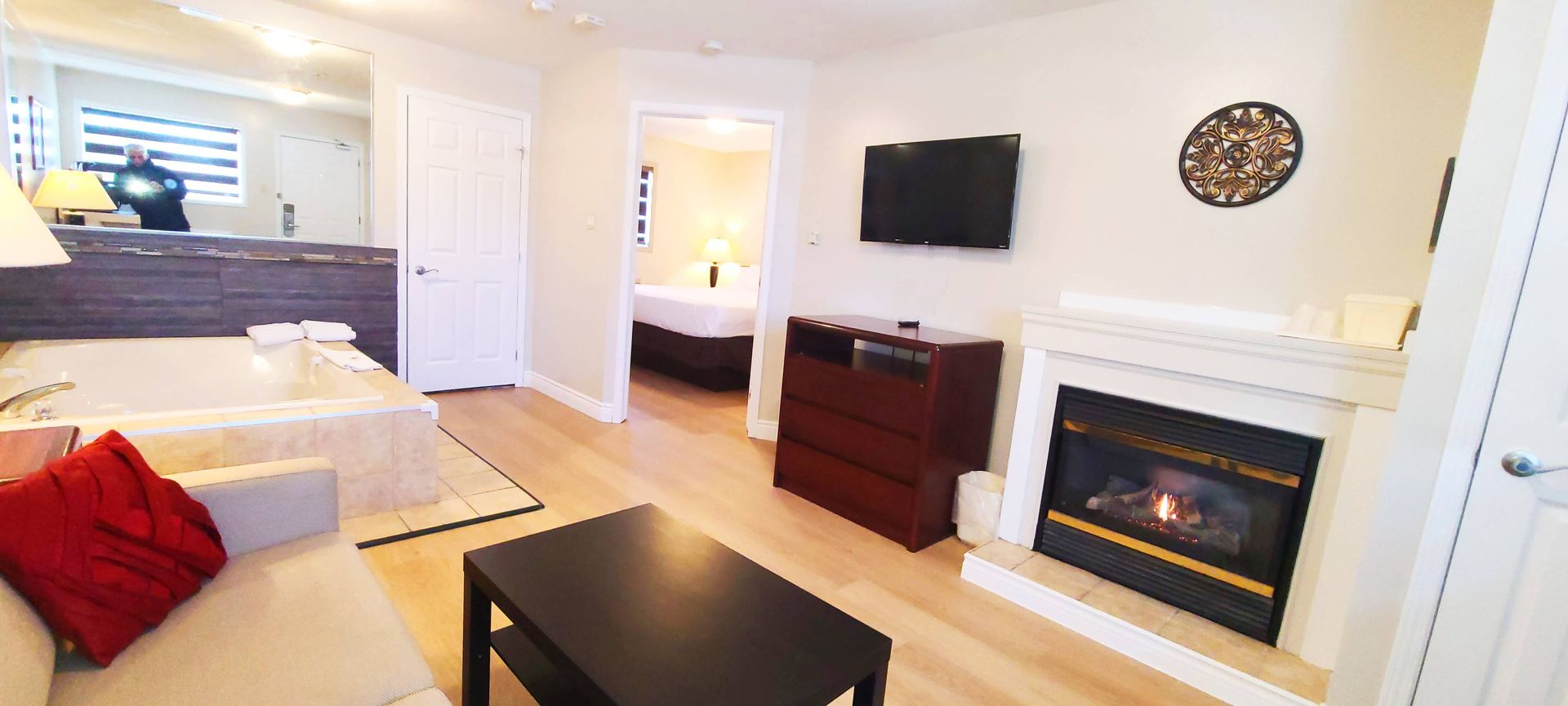 a living room with a fireplace , couch , table and television .