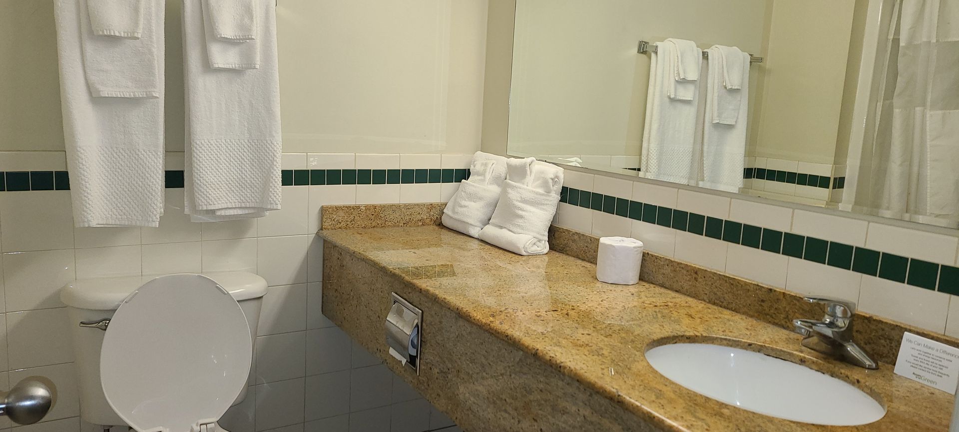 a bathroom with a toilet , sink and mirror .