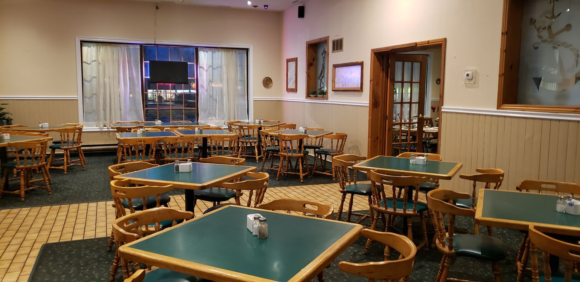 a restaurant with green tables and chairs and a large window