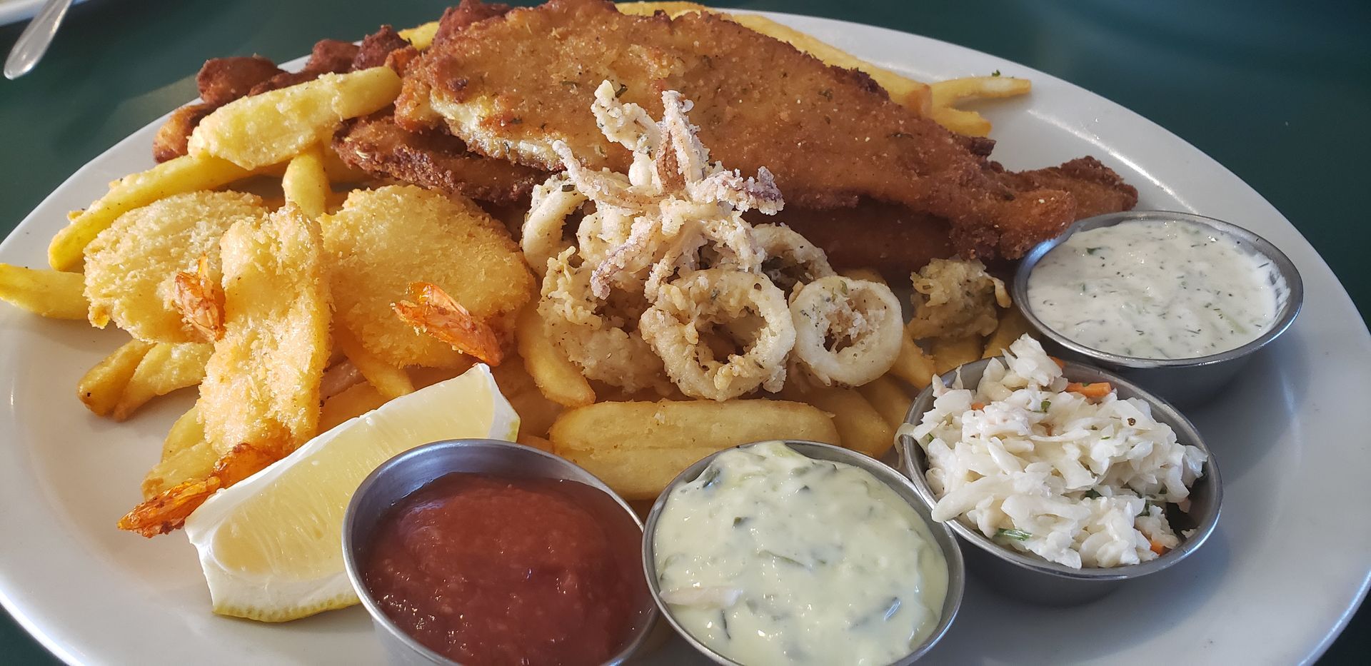 a plate of food with french fries and sauces on a table