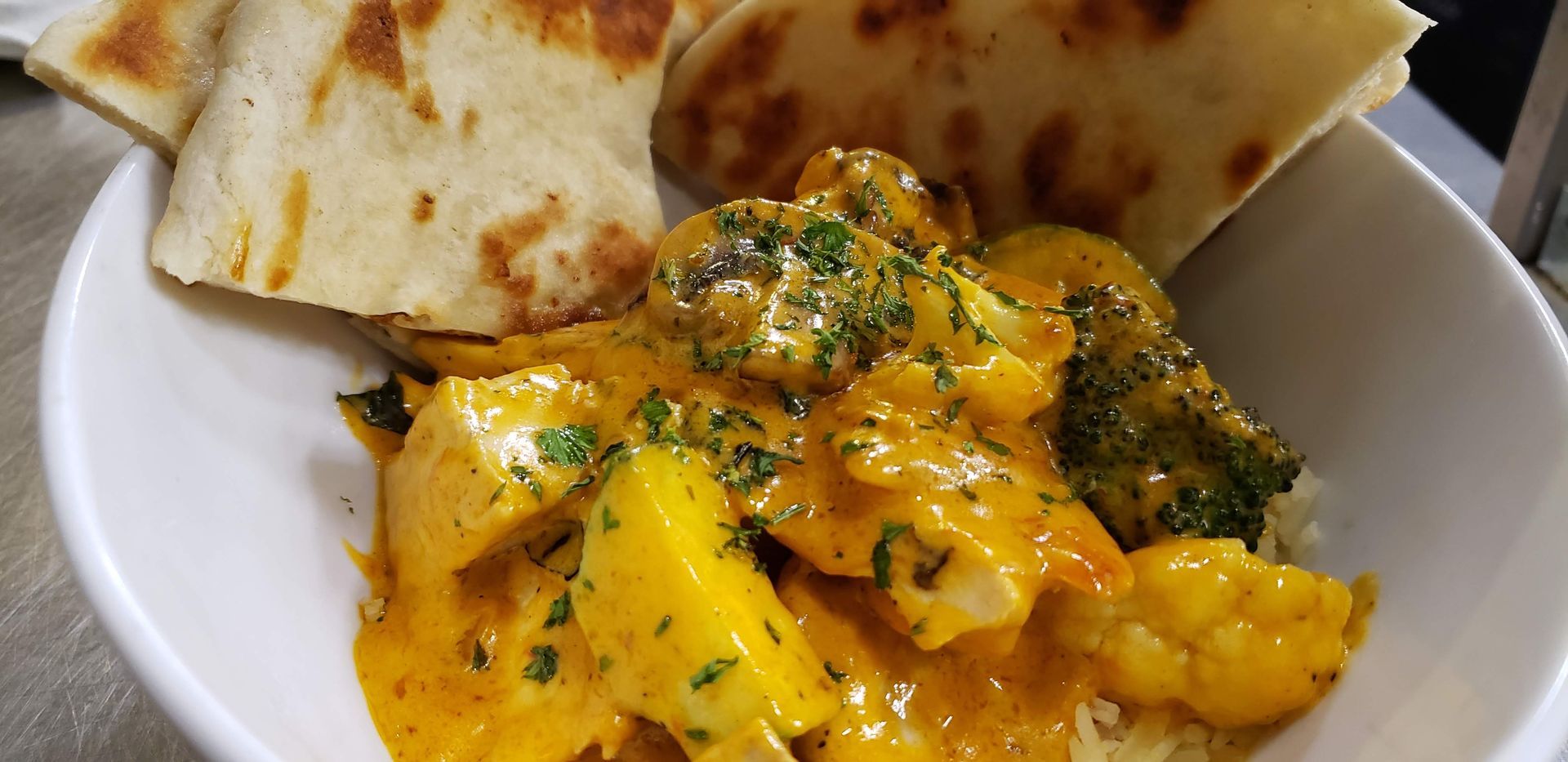 a bowl of food with rice and bread on a table .