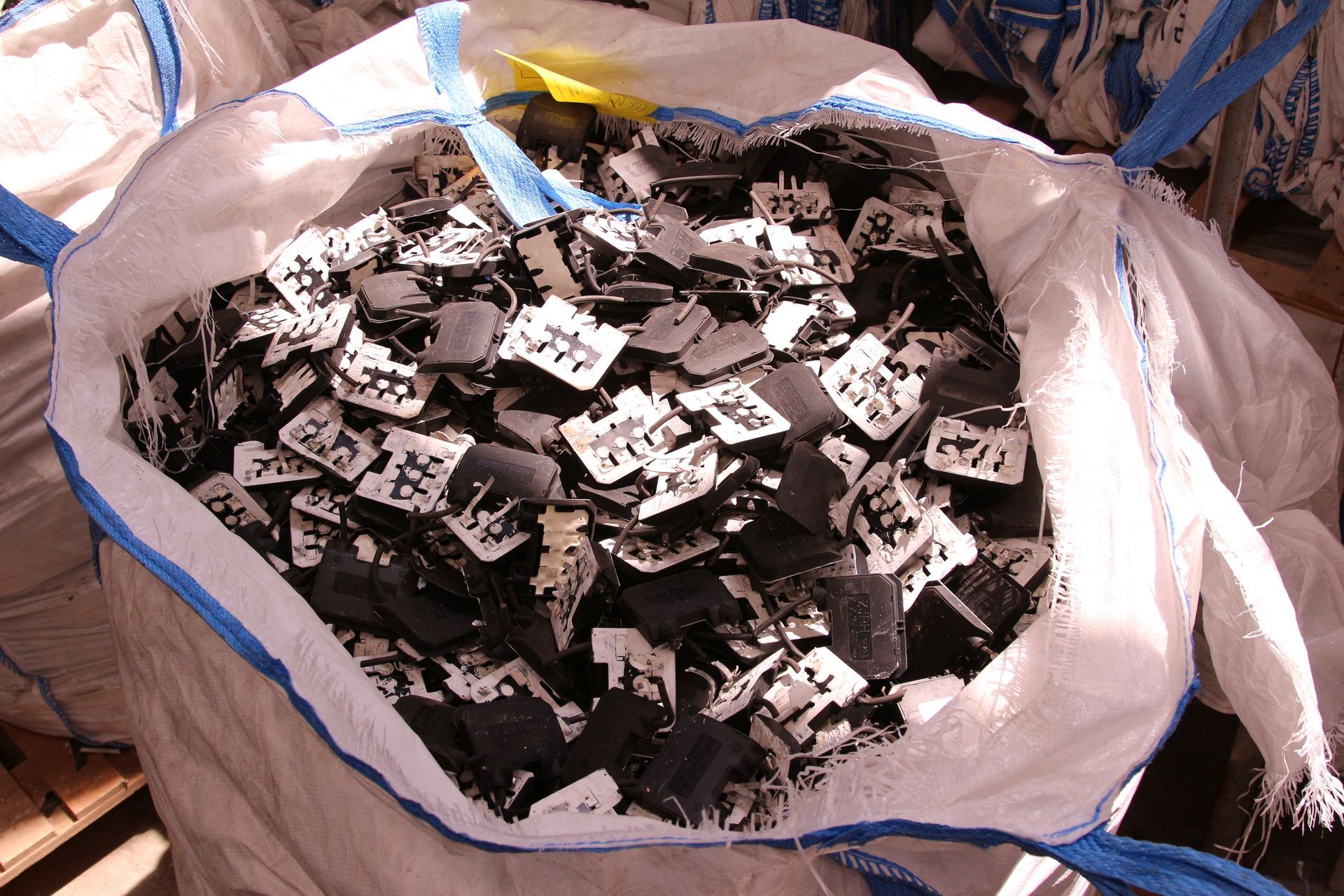 Una borsa bianca piena di pezzi di metallo bianchi e neri