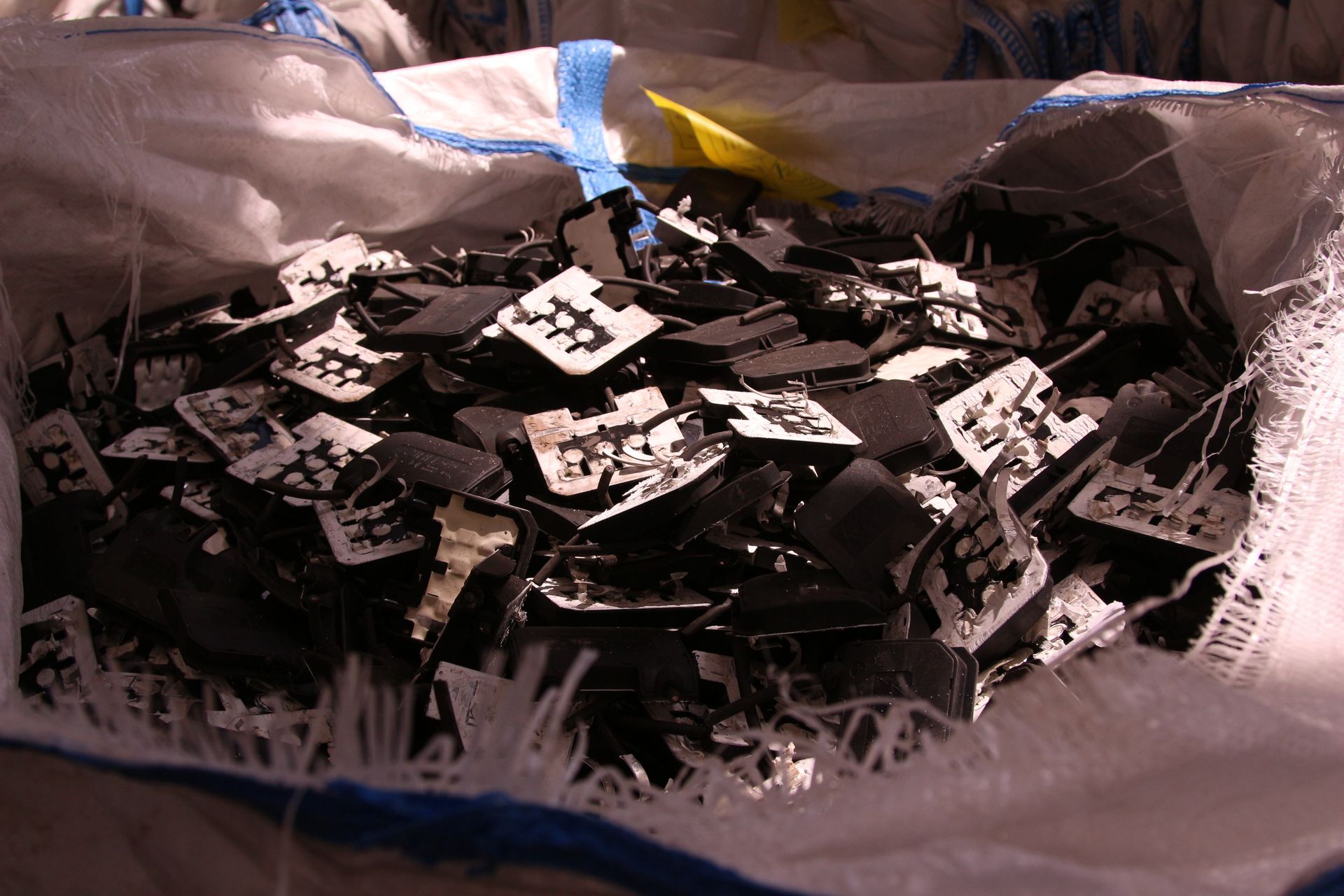 Un sacco bianco pieno di tanti pezzi di vetro rotto