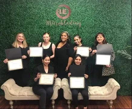 A group of women are posing for a picture while holding certificates.