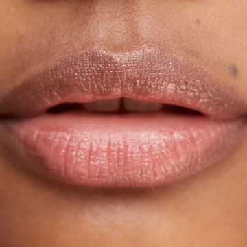 A close up of a woman 's lips with lipstick on.