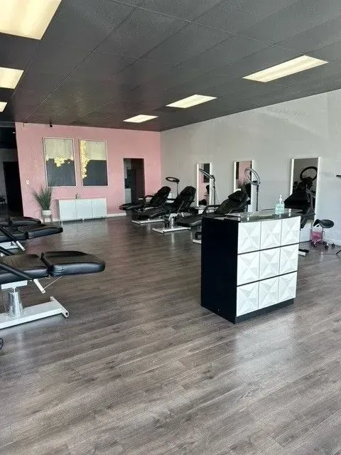 A large room with lots of chairs and a counter in a salon.