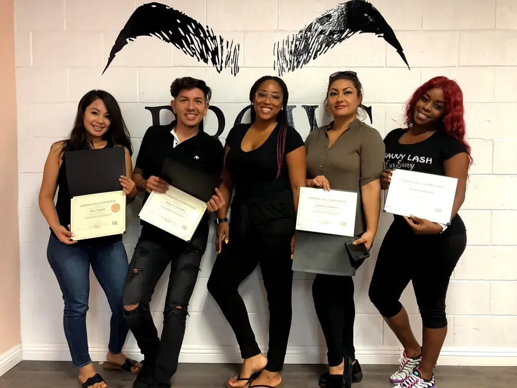 A group of people standing next to each other holding certificates