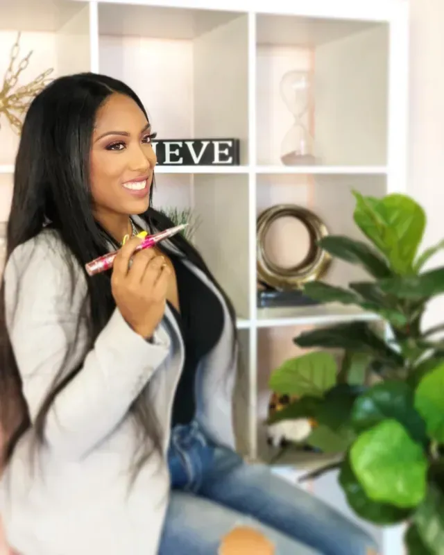 A woman is sitting in front of a sign that says eve