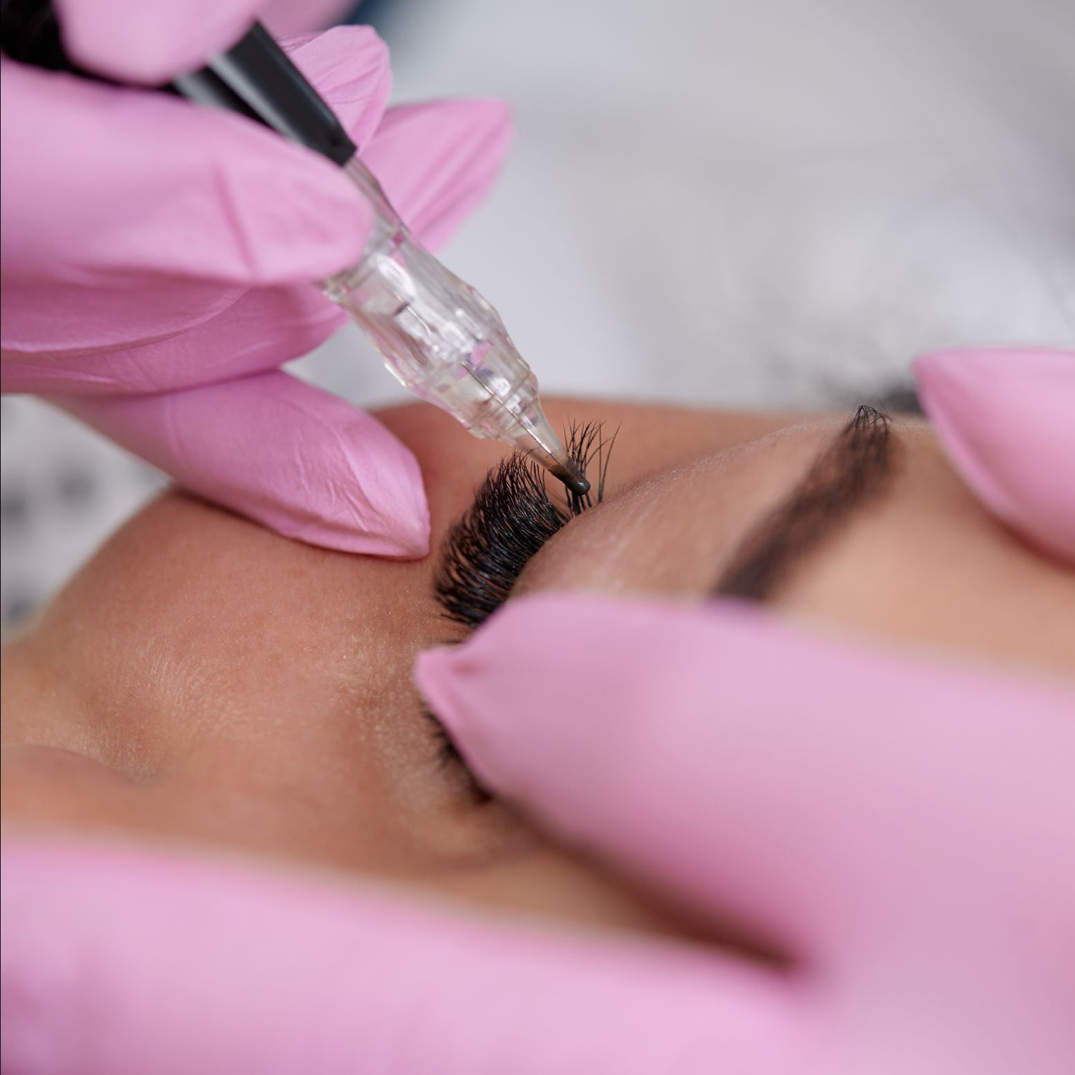 A woman is getting permanent makeup on her eyebrows.