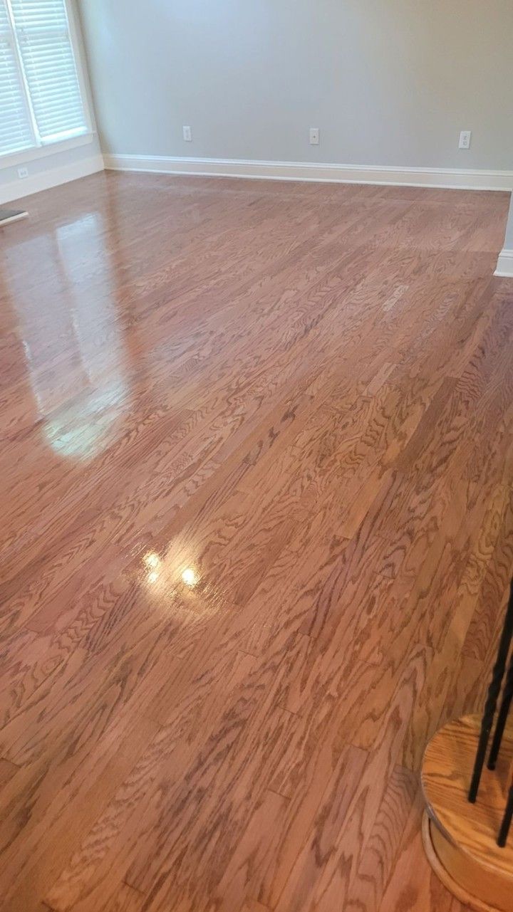 Wooden flooring in a room with light walls, natural light, and a reflection.