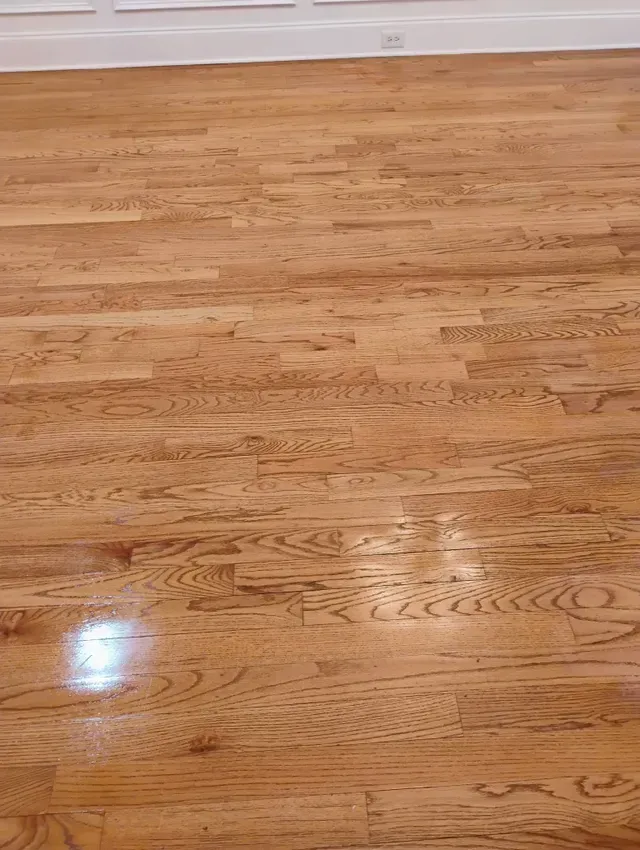 Light brown hardwood floor with some shiny spots.