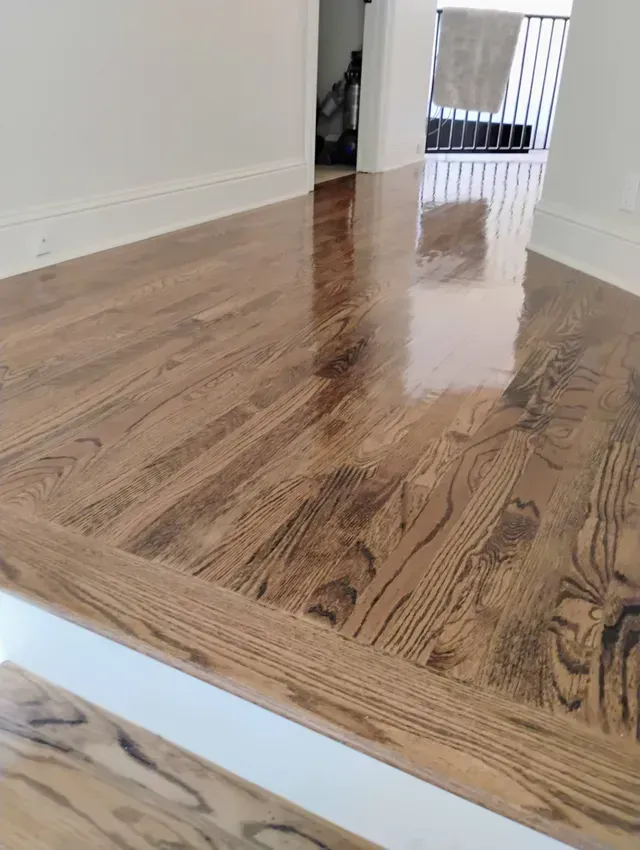 Newly refinished hardwood floors with a shiny, glossy finish.