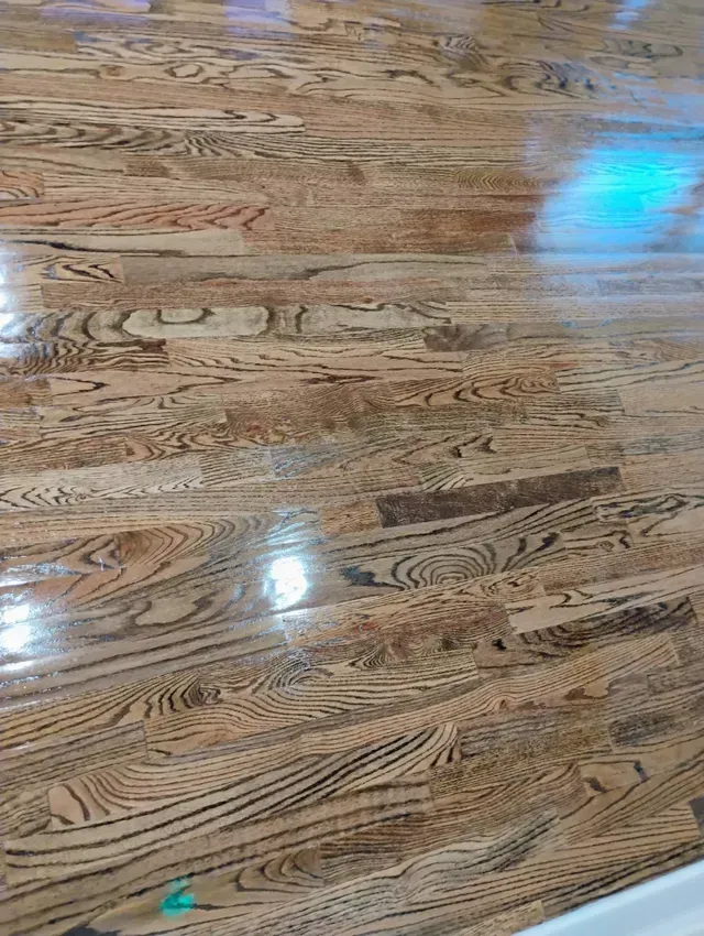 Polished wood floor with swirling grain patterns and light reflections.