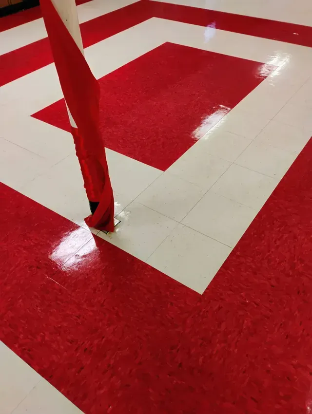 Red and white patterned floor with a red object resting on it.