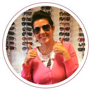 Una mujer que lleva gafas de sol está haciendo un gesto de aprobación con el pulgar hacia arriba.