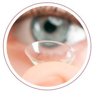 Una persona sostiene una lente de contacto delante de su ojo.