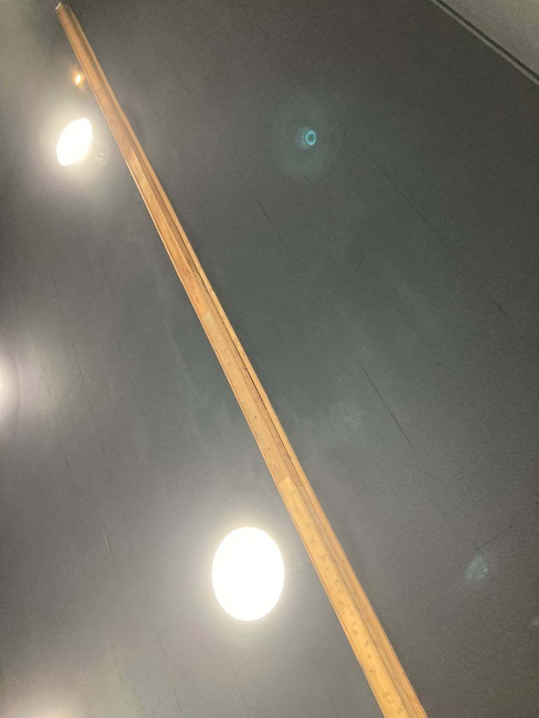 Wooden trim with a series of lights on a dark background.