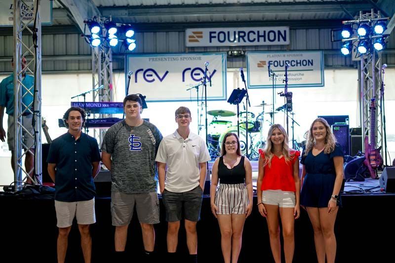 A group of young people are standing in front of a stage.