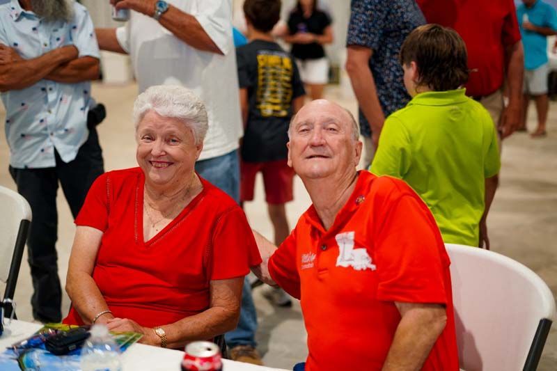 A man and a woman are sitting at a table with a group of people.