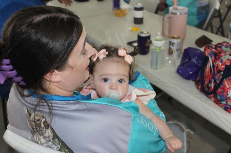 A woman is holding a baby with a pacifier in her mouth.