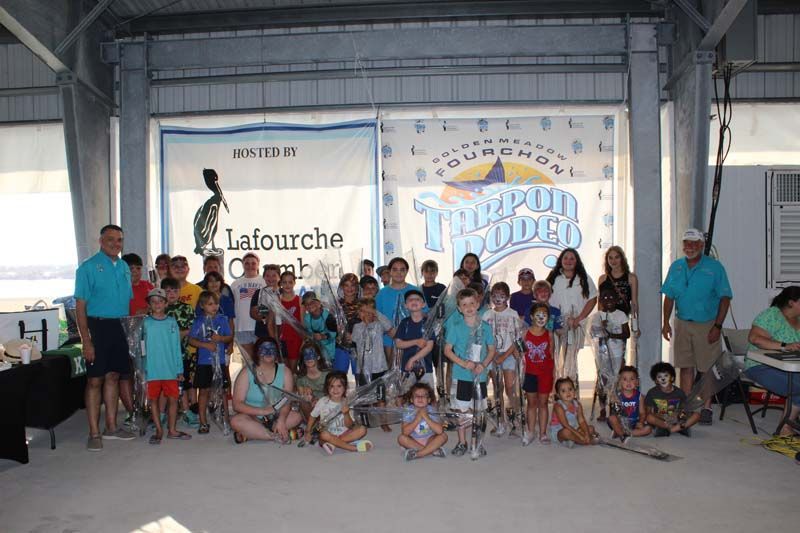 A group of people are posing for a picture in front of a sign that says lafourche