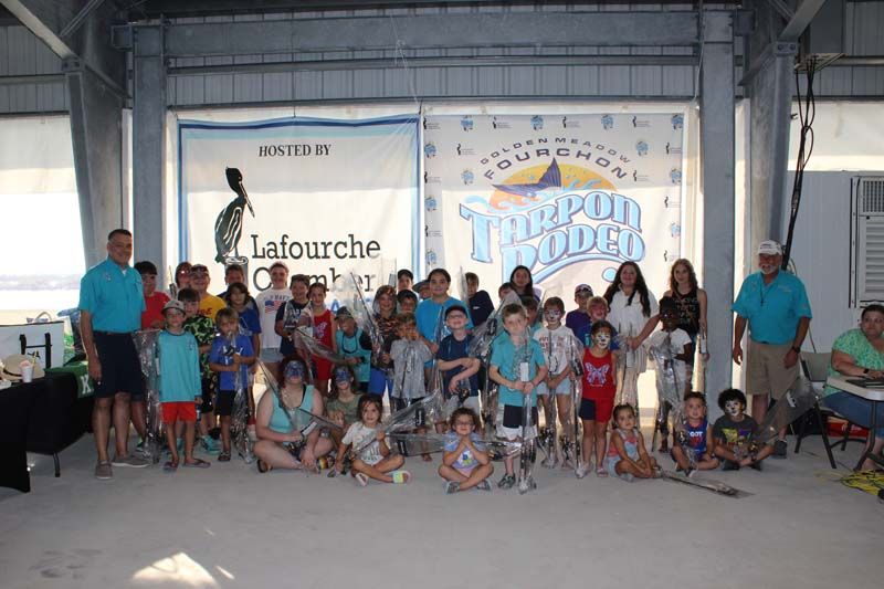 A group of people are posing for a picture in front of a sign that says triumph roller