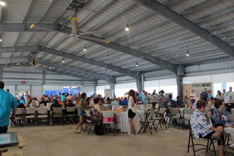 A large room filled with people sitting at tables and chairs.