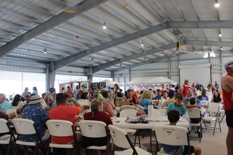 A large group of people are sitting at tables in a large room.