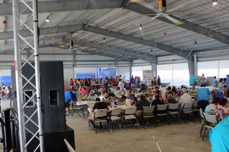 A large group of people are sitting at tables in a large room.