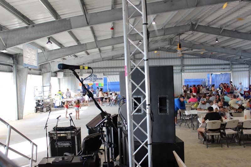 A large room with people sitting at tables and a stage