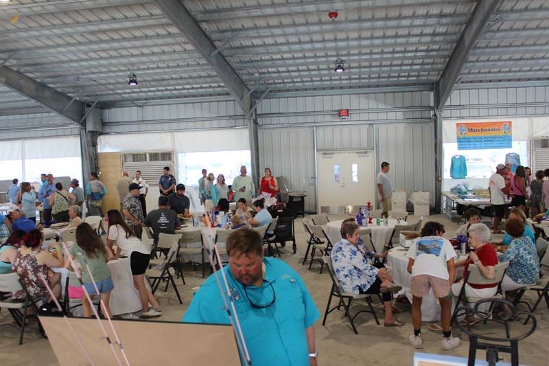A group of people are sitting at tables in a large room.