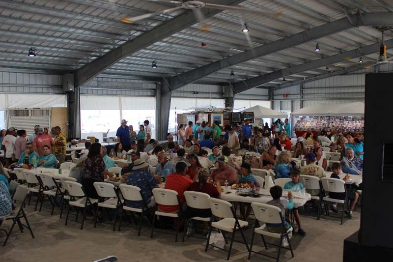 A large group of people are sitting at tables in a large room.