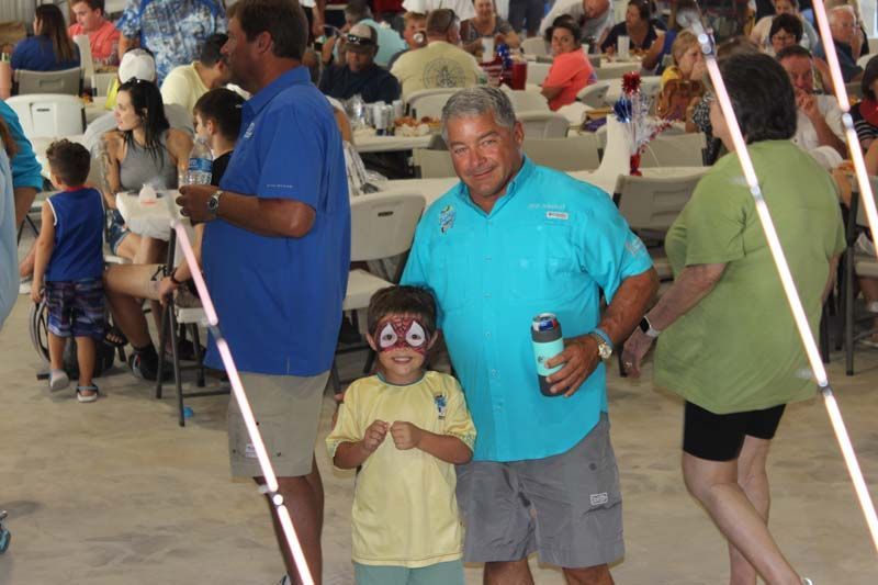 A man and a child are posing for a picture at a party