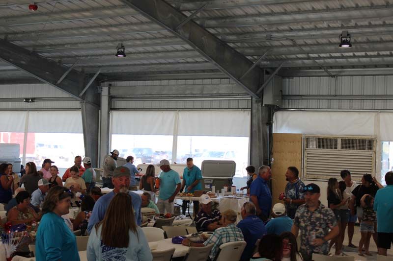A large group of people are sitting at tables in a large room.