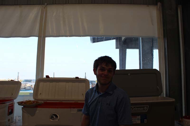 A man standing in front of a window with coolers in the background
