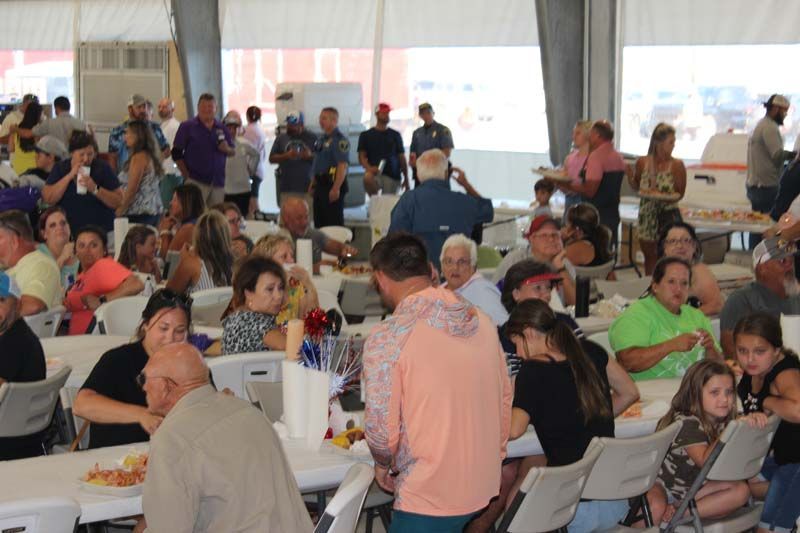 A large group of people are sitting at tables eating food