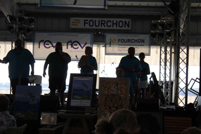 A group of people standing in front of a sign that says fourchon