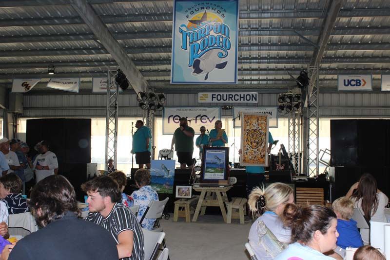 A group of people are sitting at tables in front of a sign that says thunder valley
