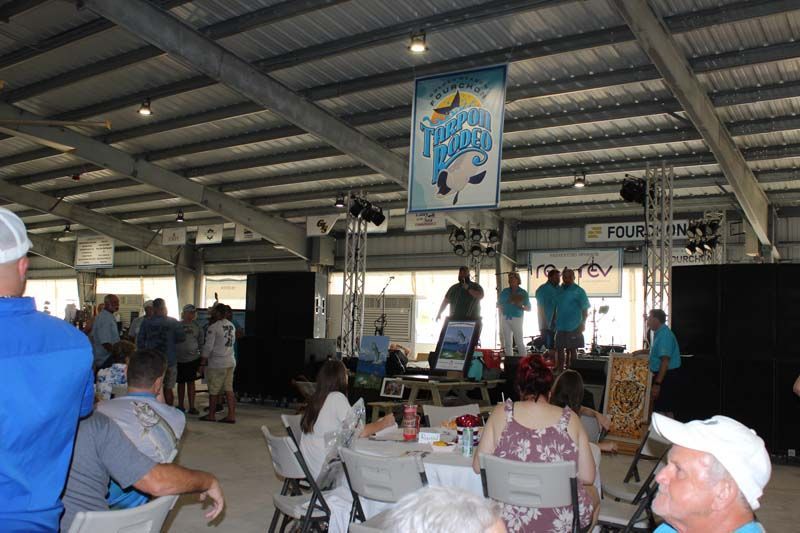 A group of people are sitting at tables in a large room.