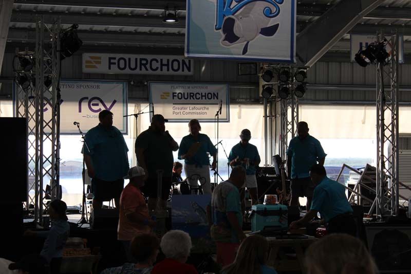A group of people standing in front of a sign that says fourchon