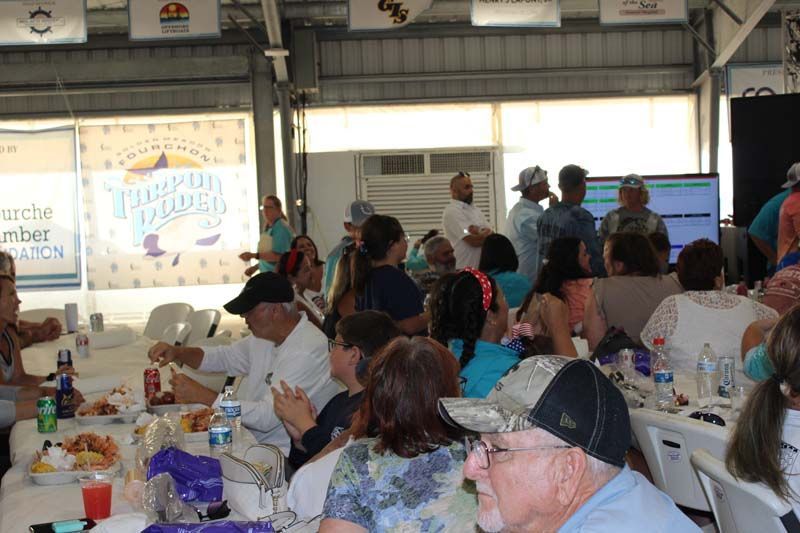 A group of people are sitting at tables eating food.