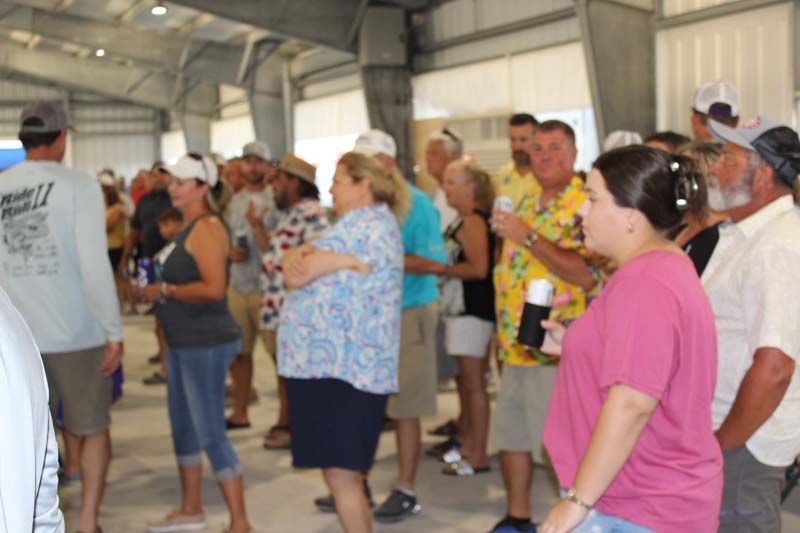 A group of people are standing in a room talking to each other.