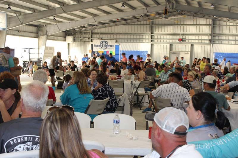 A large group of people are sitting at tables in a large room.