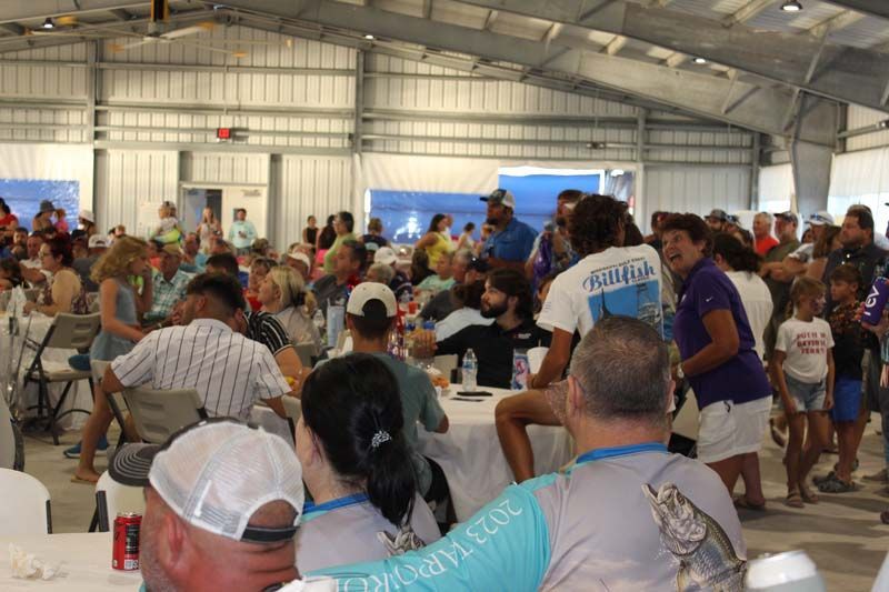 A large group of people are sitting at tables in a large room.