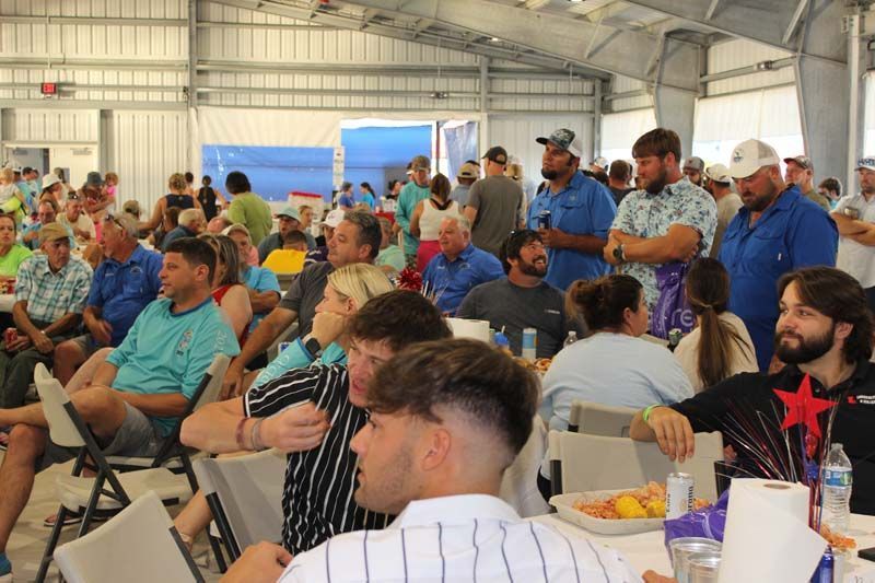 A large group of people are sitting at tables in a room.