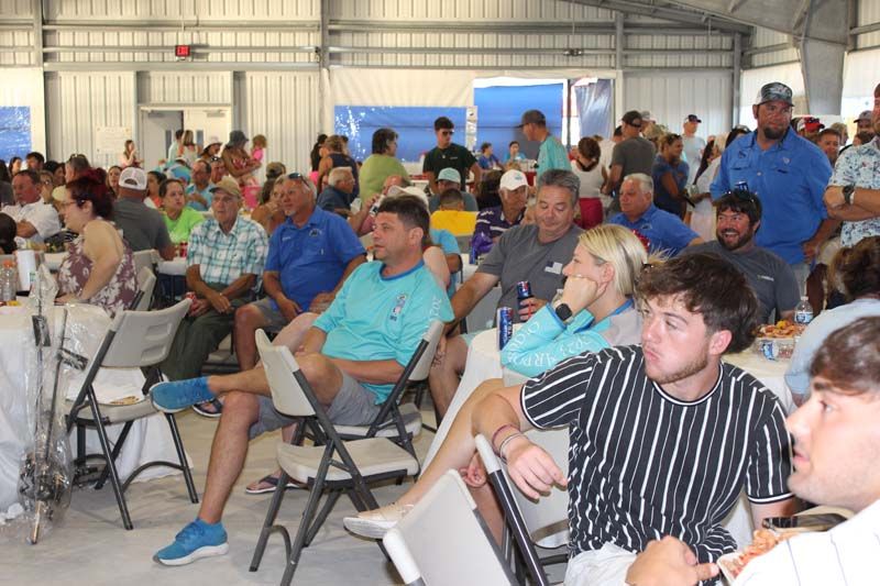 A large group of people are sitting in folding chairs in a room.