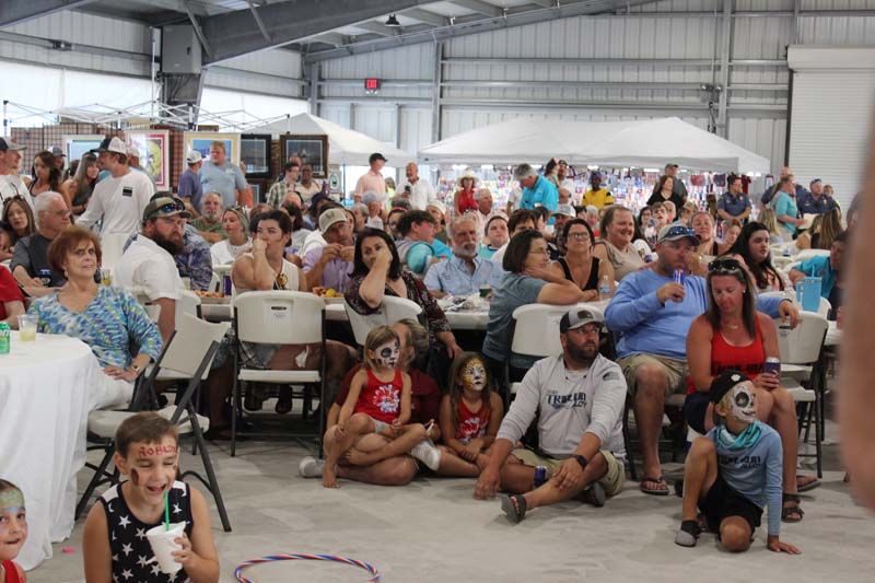 A large group of people are sitting in chairs watching a show.