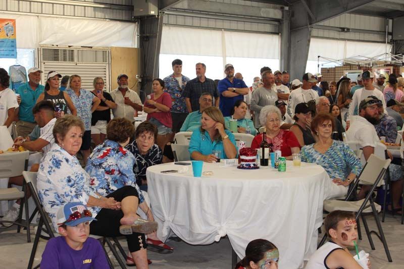 A large group of people are sitting at tables in a room.
